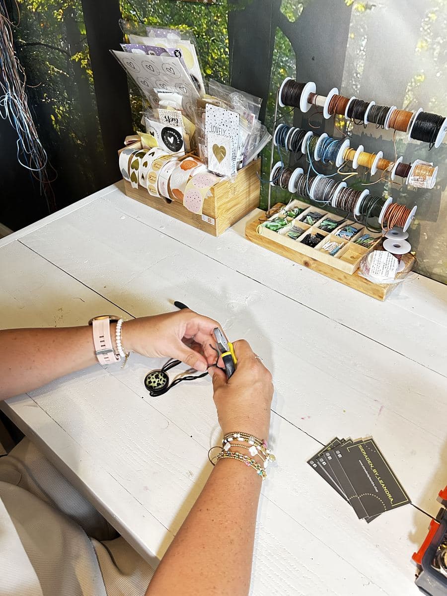 Leandra maakt een hanger aan de werktafel